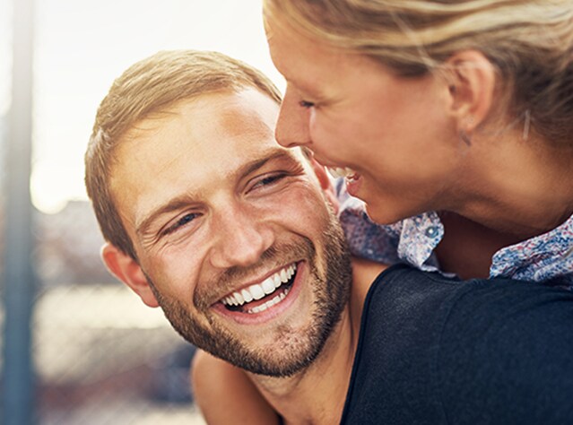 Një çift i ri duke buzëqeshur e duke kaluar shkëlqyeshëm, të lumtur pas trajtimit me Canesten®